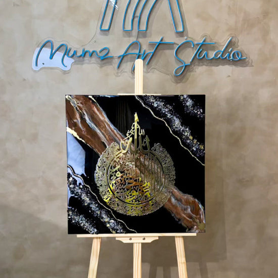 a Ayatul Kursi Resin Wall Art | 60 × 60 cm | Black, Brown & White in a wooden stand