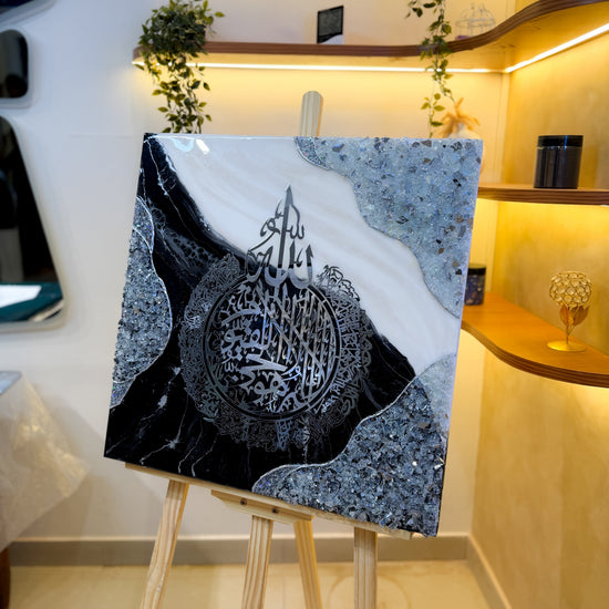 Handcrafted Ayatul Kursi resin wall art in black, white, and silver, 60 × 60 cm, featuring elegant Islamic calligraphy with a glossy epoxy resin finish.
