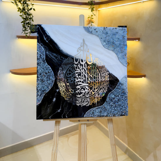 Handcrafted Ayatul Kursi resin wall art in black, white, and silver, 60 × 60 cm, featuring elegant Islamic calligraphy with a glossy epoxy resin finish.
