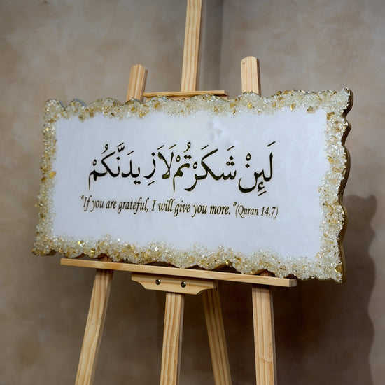 Handcrafted La'in Shakarthum Islamic resin wall art in pearly white and gold, 70 × 35 cm, featuring elegant Arabic calligraphy with a glossy high-end finish.
