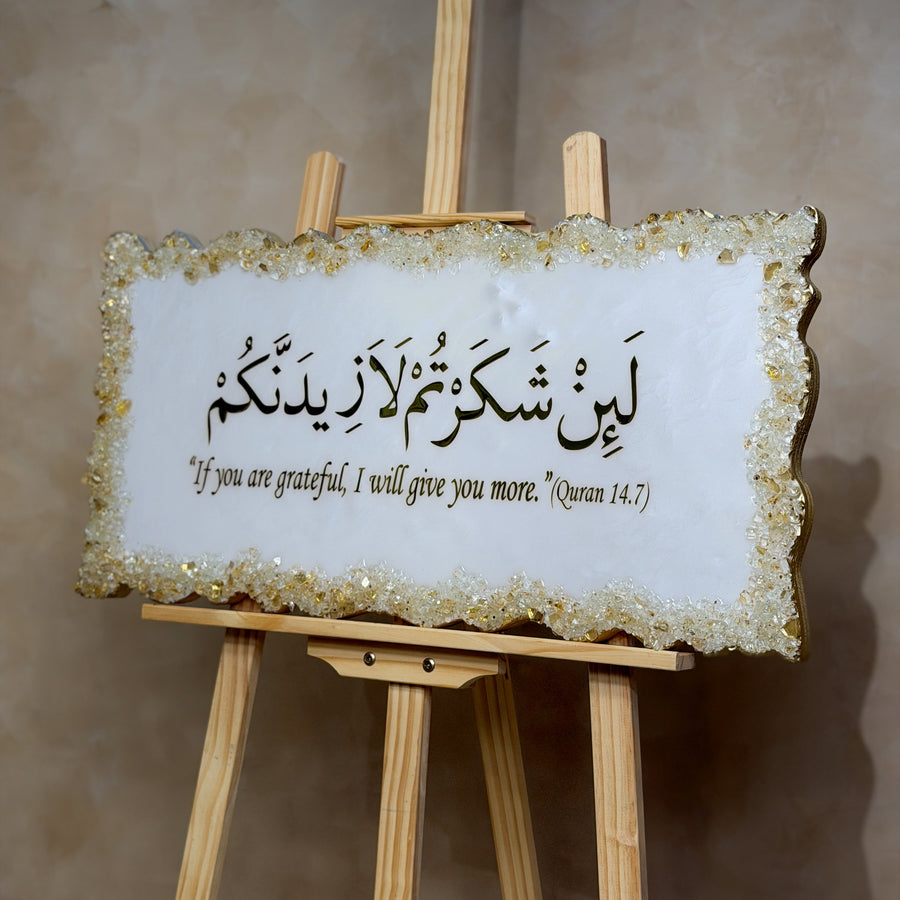 Handcrafted La'in Shakarthum Islamic resin wall art in pearly white and gold, 70 × 35 cm, featuring elegant Arabic calligraphy with a glossy high-end finish.
