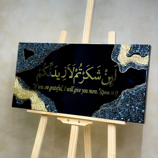Handcrafted La'in Shakarthum Islamic resin wall art in black and gold, 70 × 35 cm, made with Jet Black pigment and a glossy epoxy resin finish.