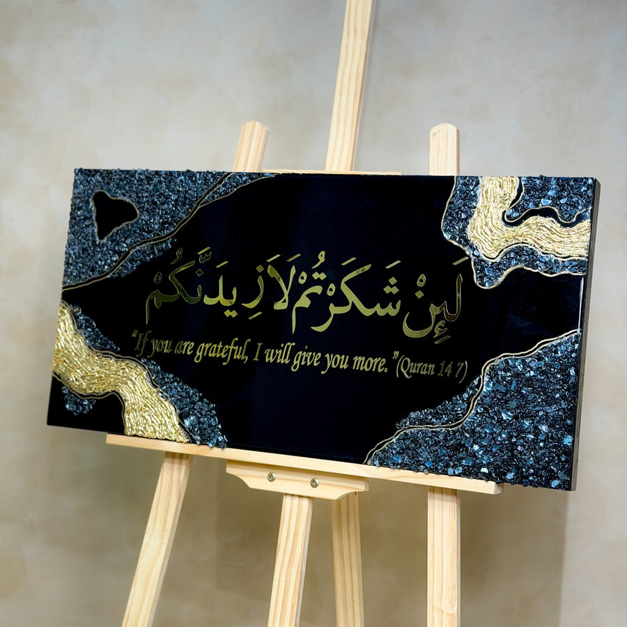 Handcrafted La'in Shakarthum Islamic resin wall art in black and gold, 70 × 35 cm, made with Jet Black pigment and a glossy epoxy resin finish.