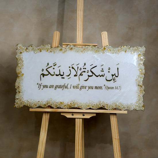 Handcrafted La'in Shakarthum Islamic resin wall art in pearly white and gold, 70 × 35 cm, featuring elegant Arabic calligraphy with a glossy high-end finish.
