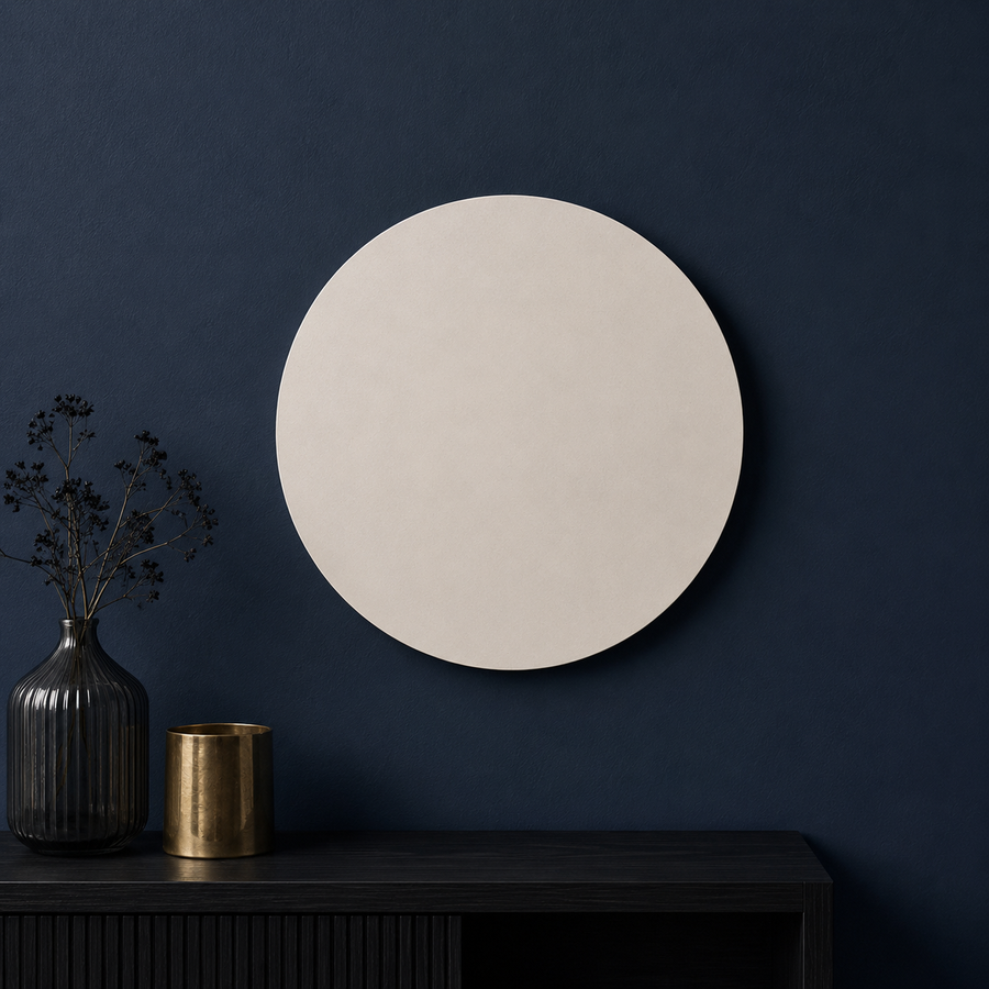 A large round off-white wall mirror with a thin black frame, mounted on a dark navy blue wall above a dark wood console table with decorative vases.